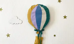 Gabarit patron montgolfière papier, cousu main, prêt à décorer une chambre d'enfant. Nuages et étoiles dorées l'accompagnent.