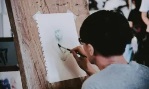 Un artiste réalise une aquarelle personnage facile sur un chevalet en bois. Le croquis est en cours de finition.