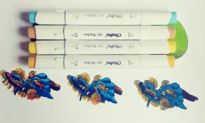 Quatre feutres à alcool Ohuhu prêts à créer un dégradé sur des dragons bleus et dorés.