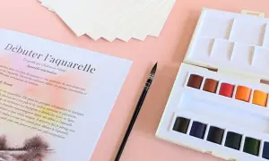Kit de matériel peinture aquarelle : palette de couleurs vives, pinceau fin et papier texturé pour débuter.
