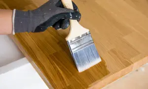 Application d'un mélange huile de lin et white spirit sur un plateau en bois. Le dosage est parfait pour une finition lisse.