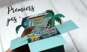 Carte pop-up plage avec cabine de sauveteur, palmier, parasol et transat.