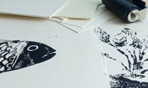 Poisson et plante en impression sur papier Canson. Un rouleau d'encrage est visible en arrière-plan, prêt pour une nouvelle création.