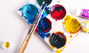 Palette de peinture avec des couleurs vives, des pinceaux et des tubes de peinture. La composition du papier est prête pour une nouvelle création artistique.