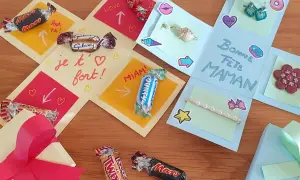 Boîte cadeau explosion décorée de chocolats, de messages et de petits cadeaux pour la fête des mères.