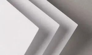 Trois feuilles de papier blanc superposées, créant un effet d'escalier. La texture du papier rappelle celle d'un **format raisin** pour une œuvre d'art.