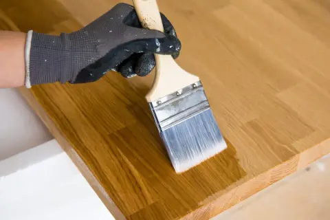 Application d'un mélange huile de lin et white spirit sur un plateau en bois. Le dosage est parfait pour une finition lisse.