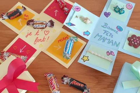 Boîte cadeau explosion décorée de chocolats, de messages et de petits cadeaux pour la fête des mères.