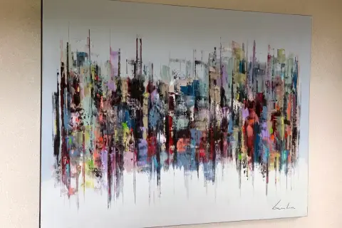 Peinture abstraite d'une ville aux couleurs vives, évoquant l'énergie d'un artiste contemporain.