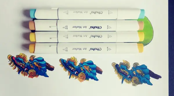 Quatre feutres à alcool Ohuhu prêts à créer un dégradé sur des dragons bleus et dorés.