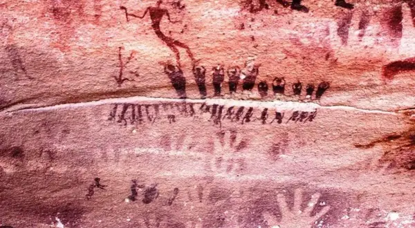 Traces de mains et figures humaines stylisées sur la paroi de la grotte de Lascaux, témoins d'une ancienne présence.