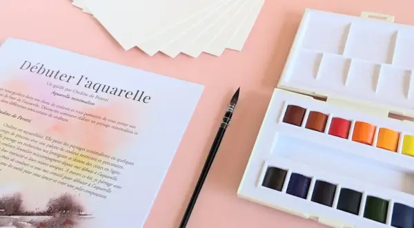 Kit de matériel peinture aquarelle : palette de couleurs vives, pinceau fin et papier texturé pour débuter.