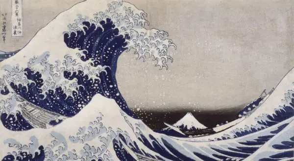 Vague déferlante bleue avec des bateaux et le mont Fuji au loin.