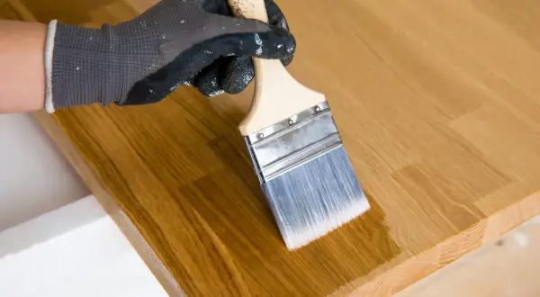 Application d'un mélange huile de lin et white spirit sur un plateau en bois. Le dosage est parfait pour une finition lisse.