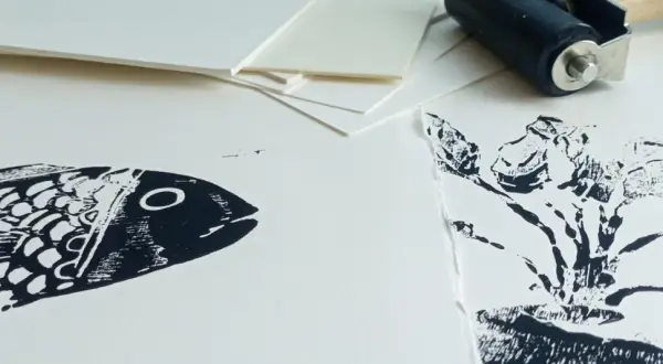 Poisson et plante en impression sur papier Canson. Un rouleau d'encrage est visible en arrière-plan, prêt pour une nouvelle création.