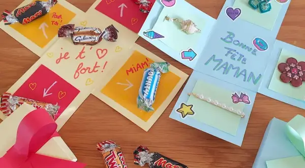 Boîte cadeau explosion décorée de chocolats, de messages et de petits cadeaux pour la fête des mères.