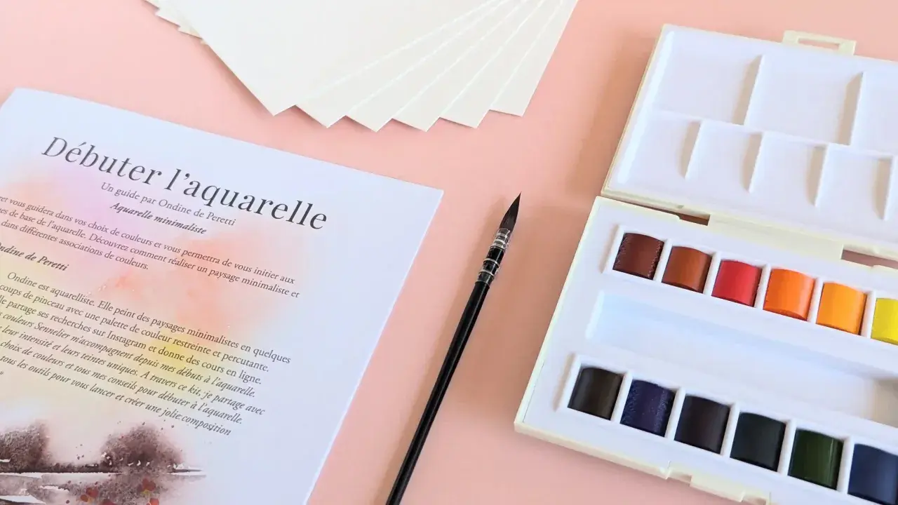 Kit de matériel peinture aquarelle : palette de couleurs vives, pinceau fin et papier texturé pour débuter.