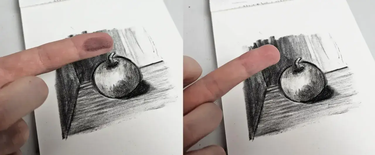 Un doigt est utilisé pour estomper un dessin au fusain d'une pomme, technique d'un artiste connu.