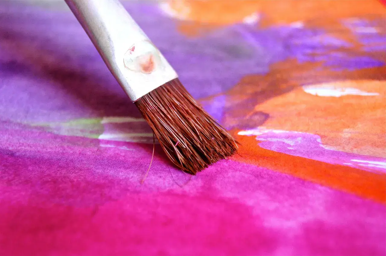 Un pinceau éventail en action, créant des touches de couleur vibrantes sur une œuvre d'art abstraite. Son utilisation est parfaite pour des dégradés doux.