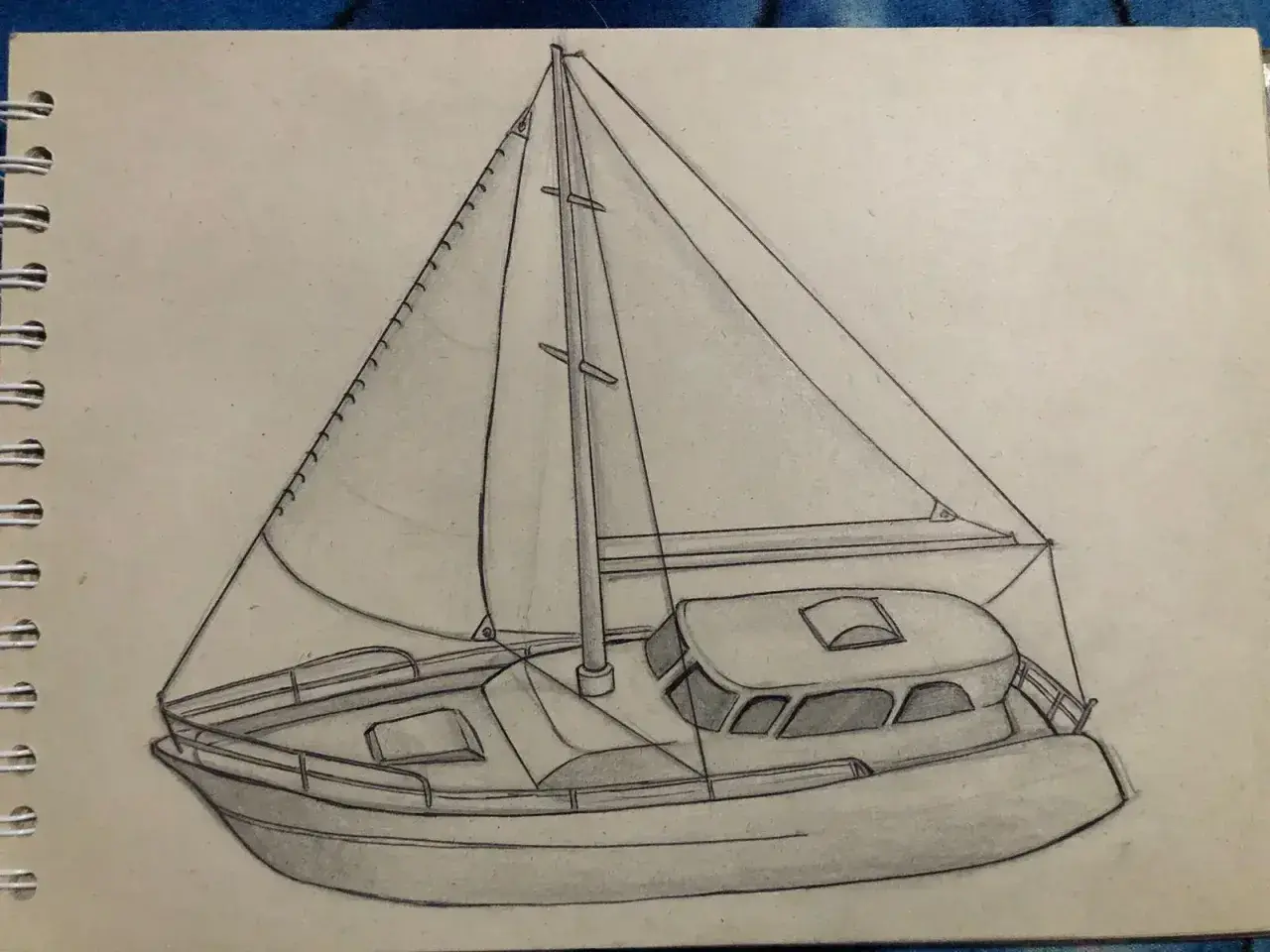 Un dessin au crayon d'un voilier avec ses voiles gonflées par le vent, prêt à naviguer.