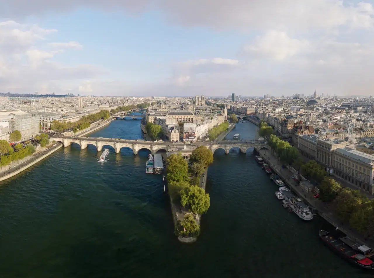 Vue a&eacute;rienne de Paris, un tableau vivant de la Seine, des ponts et des b&acirc;timents embl&eacute;matiques sous un ciel nuageux.