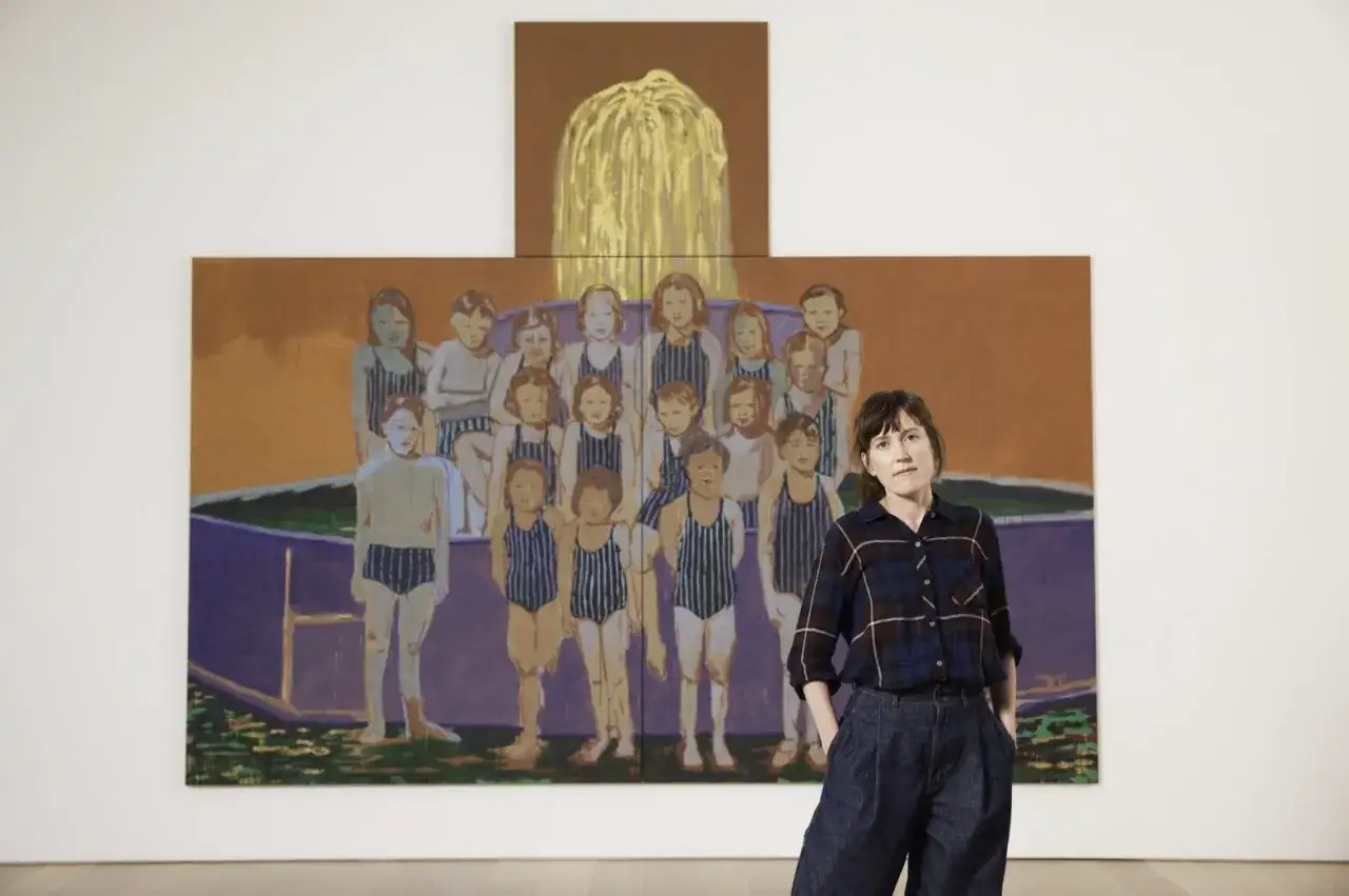 Une femme se tient devant une peinture de groupe d'enfants en maillot de bain, &oelig;uvre d'un peintre hollandais contemporain.