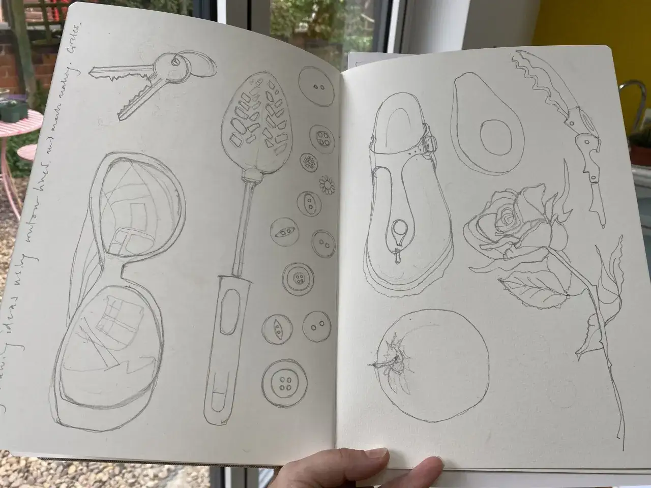 Carnet de croquis rempli d'id&eacute;es de dessin : cl&eacute;s, lunettes, cuill&egrave;re, boutons, avocat, rose, tomate et sandale.