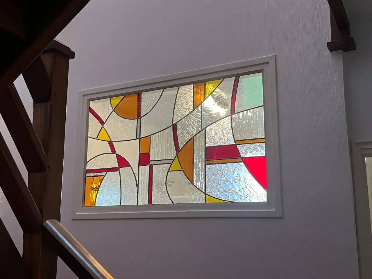 Un vitrail aux formes abstraites, aux couleurs vives et douces, comme un dessin vitrail facile. La lumi&egrave;re traverse les verres textur&eacute;s et color&eacute;s.
