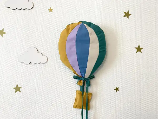 Gabarit patron montgolfière papier, cousu main, prêt à décorer une chambre d'enfant. Nuages et étoiles dorées l'accompagnent.