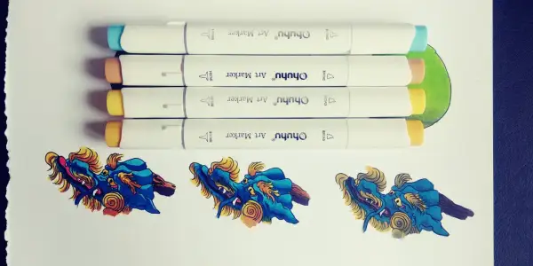 Quatre feutres à alcool Ohuhu prêts à créer un dégradé sur des dragons bleus et dorés.