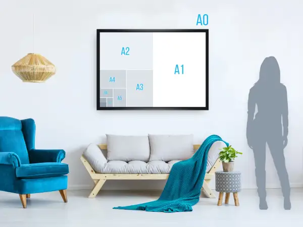 Un salon moderne avec un fauteuil bleu vif, un canapé en bois et un plaid turquoise. Un cadre mural illustre les tailles de papier, montrant que A5 est plus petit que A4.