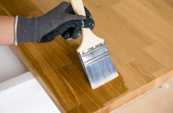 Application d'un mélange huile de lin et white spirit sur un plateau en bois. Le dosage est parfait pour une finition lisse.