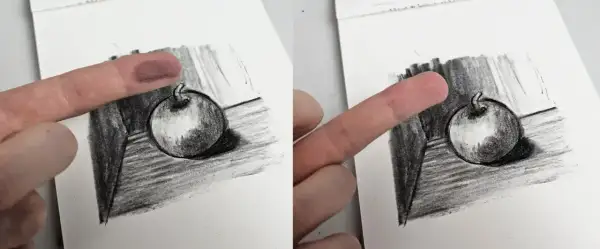Un doigt est utilisé pour estomper un dessin au fusain d'une pomme, technique d'un artiste connu.